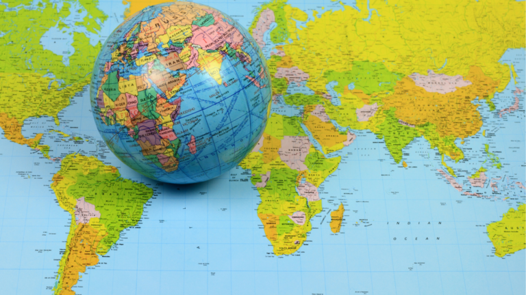 A colourful globe of the earth sitting on top of map of the world