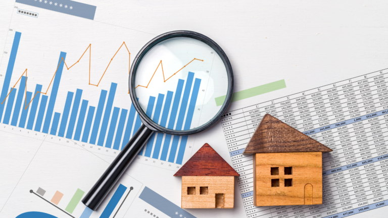Magnifying class laying on top of printed sheets of graphs, data tables and wooden blocks placed into the shape of two houses