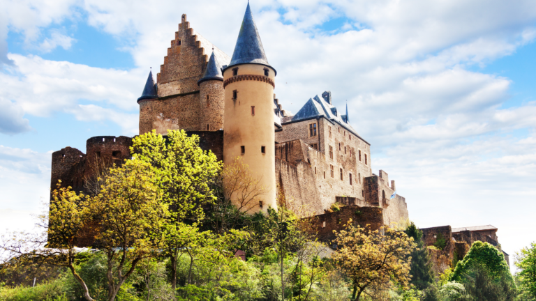 A castle with turrets surrounded by trees on a hill
