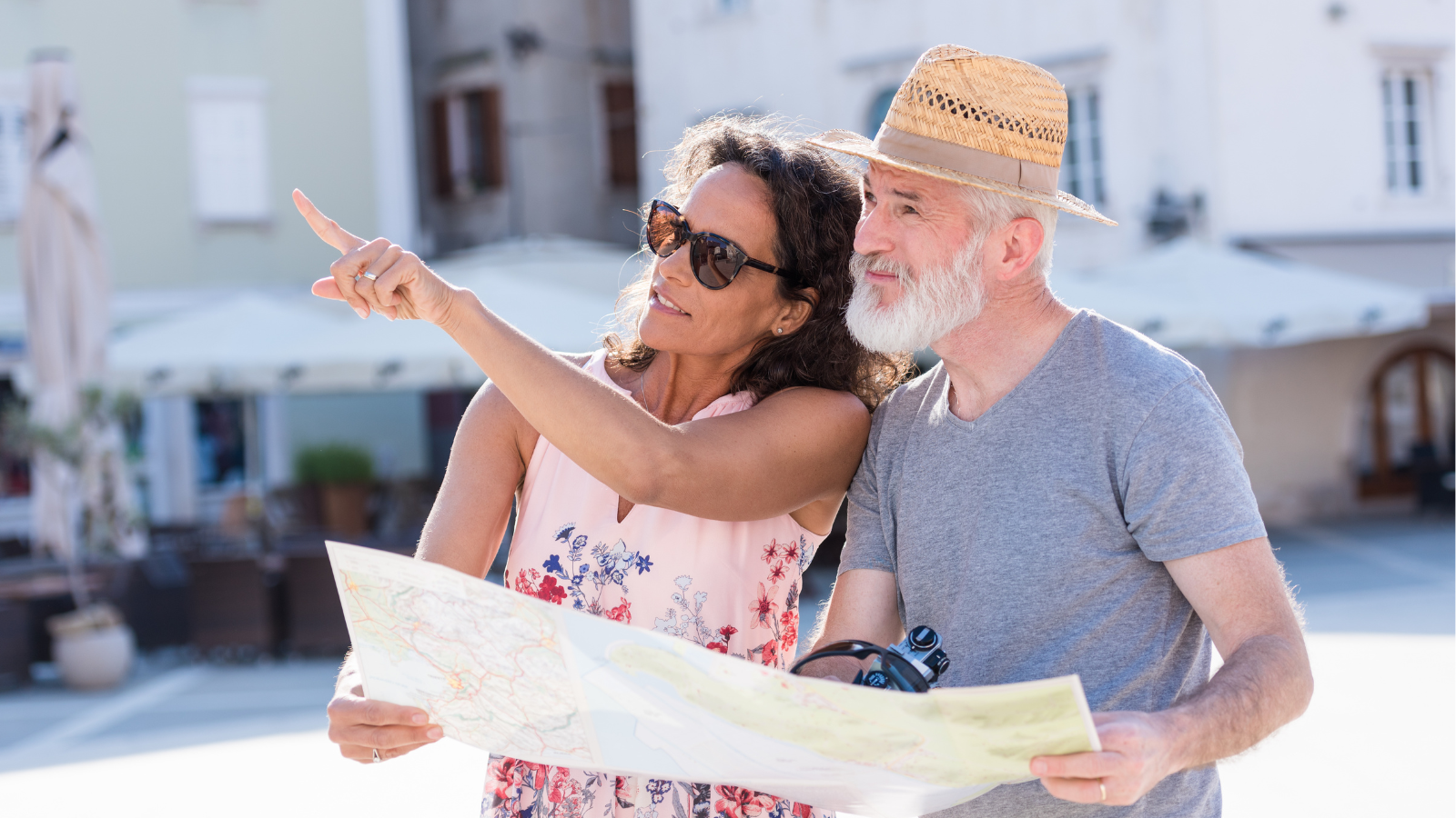 Older couple holding a map and pointing into the distance