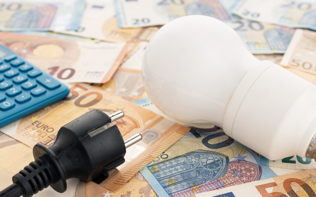 Light bulb, power cord and calculator laying across euro notes